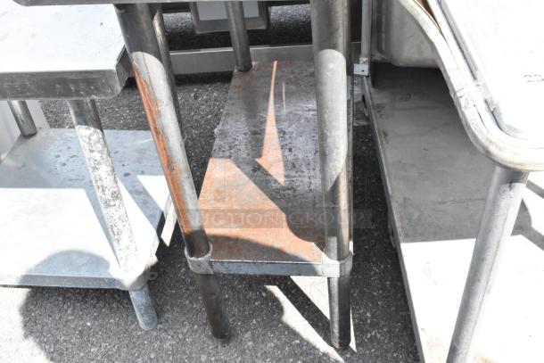 Stainless Steel Table with metal under shelf, showing signs of wear. Ideal for kitchen or industrial use.