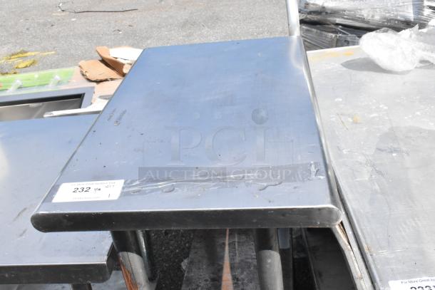 Stainless steel table with metal under shelf, minor surface marks, auction tag "232". Durable and functional design.
