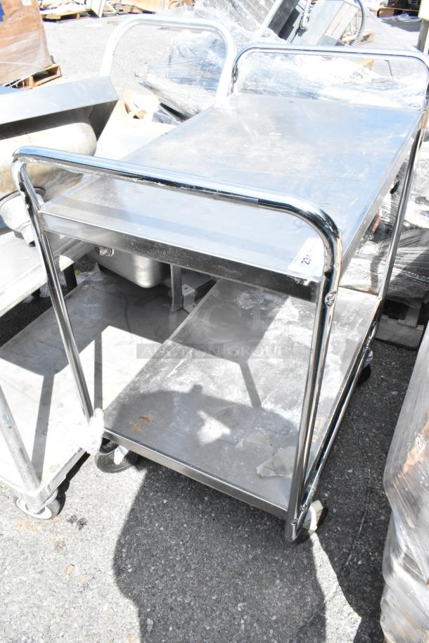Stainless steel 2-tier cart on commercial casters, durable construction, ideal for transport and storage, shows light wear.