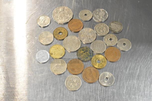 Lot of 24 various coins with different sizes, colors, and inscriptions, some with circular cutouts, showcasing diverse currencies.