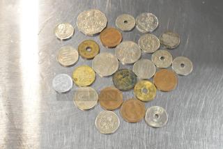 Lot of 24 various coins with different sizes, colors, and inscriptions, some with circular cutouts, showcasing diverse currencies.