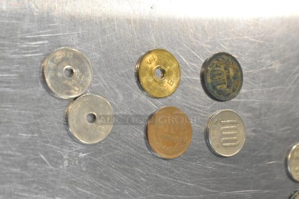 Lot of 24 mixed coins on a scratched metallic surface, featuring various denominations and designs, some with holes.