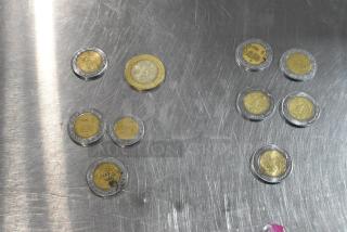 Lot of 10 various coins on silver surface; coins feature different designs and appear in varying conditions.