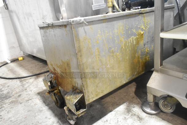 Metal commercial portable filter for fryer oil, well-used condition, visible wear and rust, 120 volts, 1 phase, on wheels.