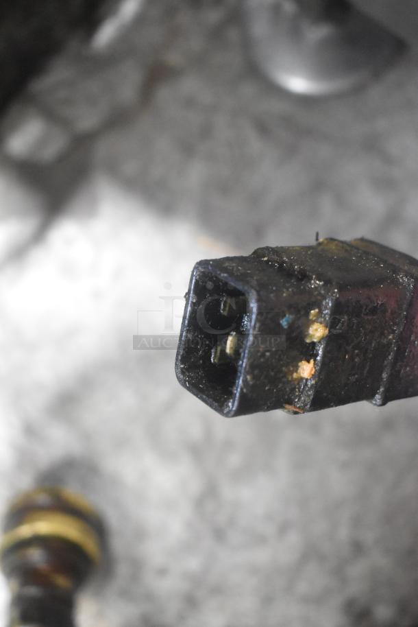 Close-up of a used electrical plug from a 402 Metal Commercial Portable Filter for Fryer Oil, 120V, 1 Phase.