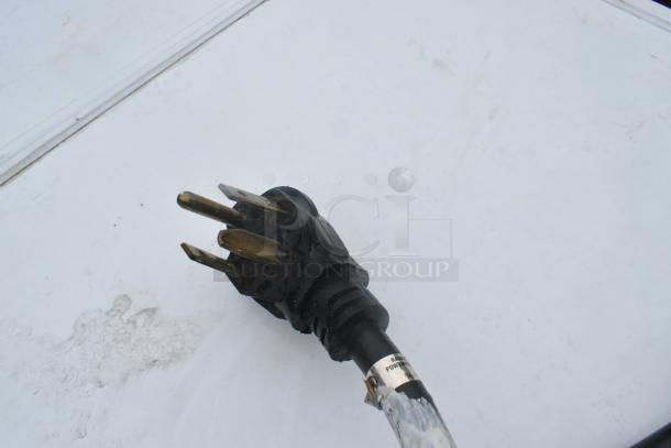 Close-up of a black power cord plug for a Whirlpool Front Load Dryer, 125/250 Volts.