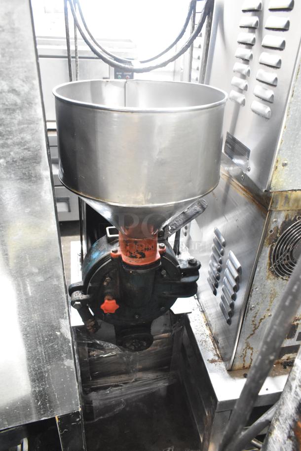Metal commercial floor-style unit with a round stainless steel hopper and industrial components, showing signs of use.