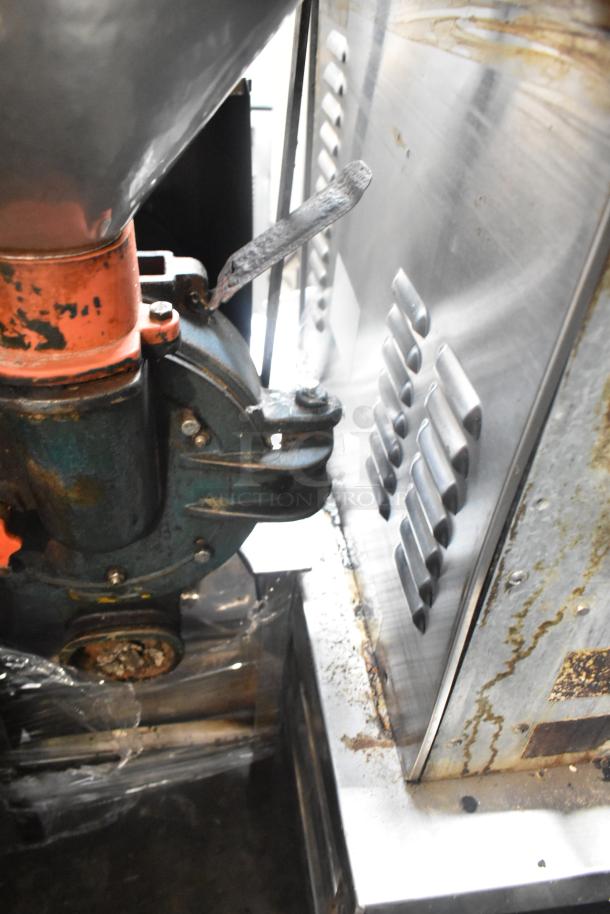 Metal commercial floor style unit, visible wear and rust, lever mechanism, industrial design.