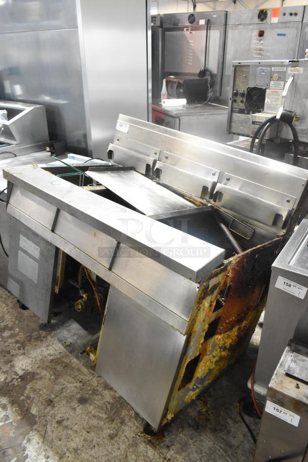 Stainless steel commercial 3 bay deep fat fryer, natural gas powered, visible rust and wear, suitable for parts or repair.