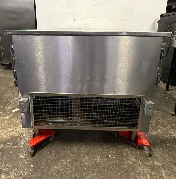 Universal Coolers worktop refrigerator with one side freezer, stainless steel, visible wear, industrial setting.