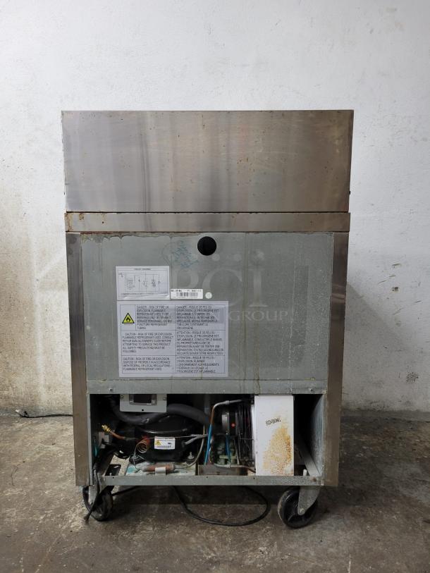 Dukers Salad Prep Station Refrigerator DSWP29, model DSP29, visible wear, labels on front, mounted on wheels.