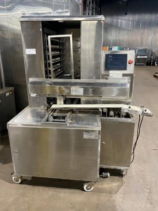 Aksar stainless steel electric tray aligning machine with pan slides, built-in control panel, on casters, in used condition.