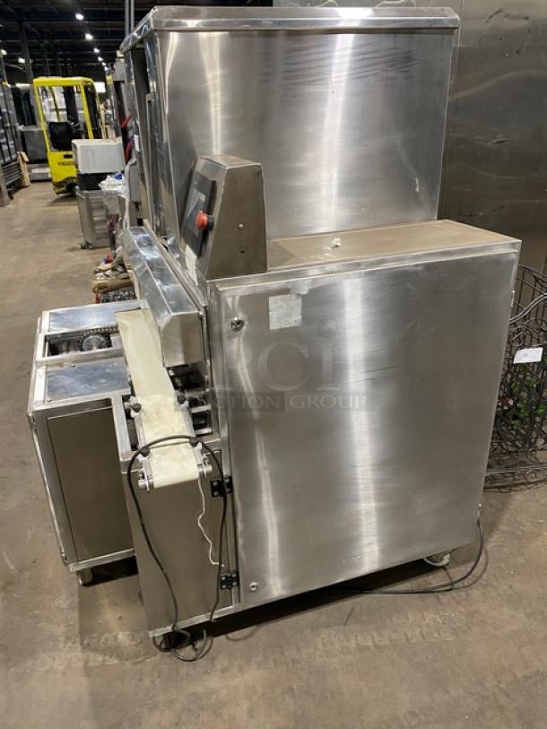 Aksar stainless steel electric tray arranging machine on casters, with built-in pan slides, in used condition.