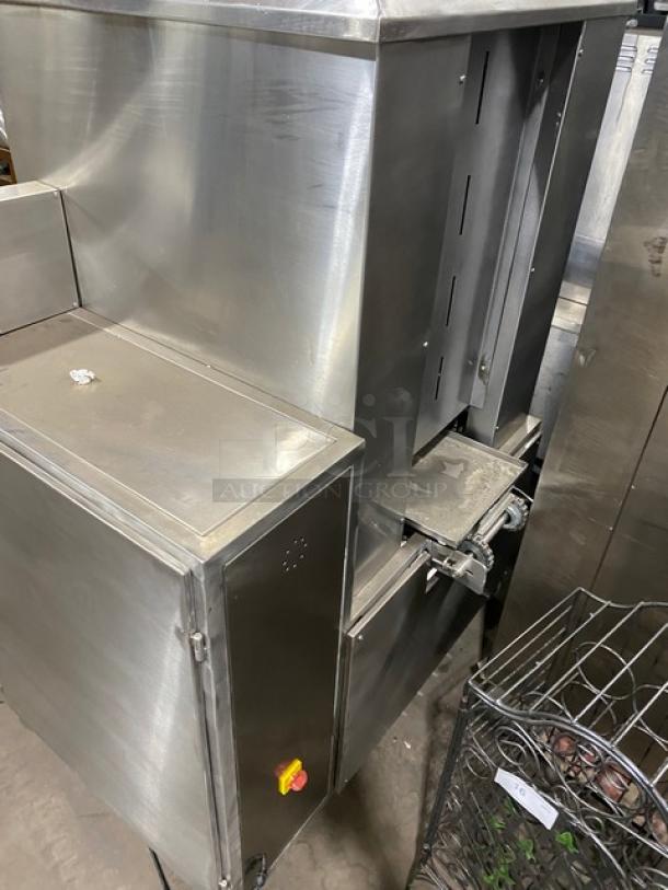 Aksar commercial stainless steel electric tray arranging machine with built-in pan slides, on casters, in good condition.