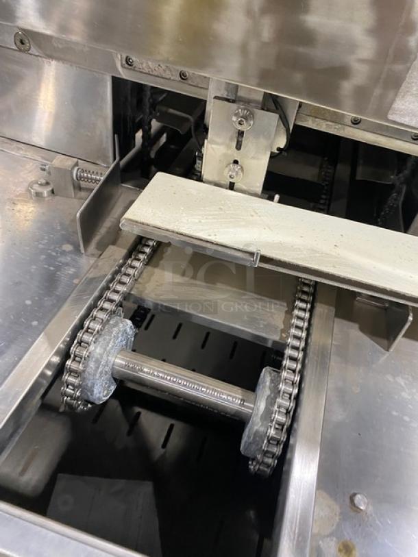 Aksar commercial stainless steel electric tray aligning machine with built-in pan slides and casters, visible chain mechanism.