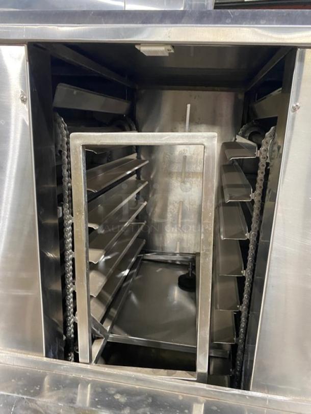 Aksar commercial stainless steel electric tray aligning machine with built-in pan slides, features casters for mobility.