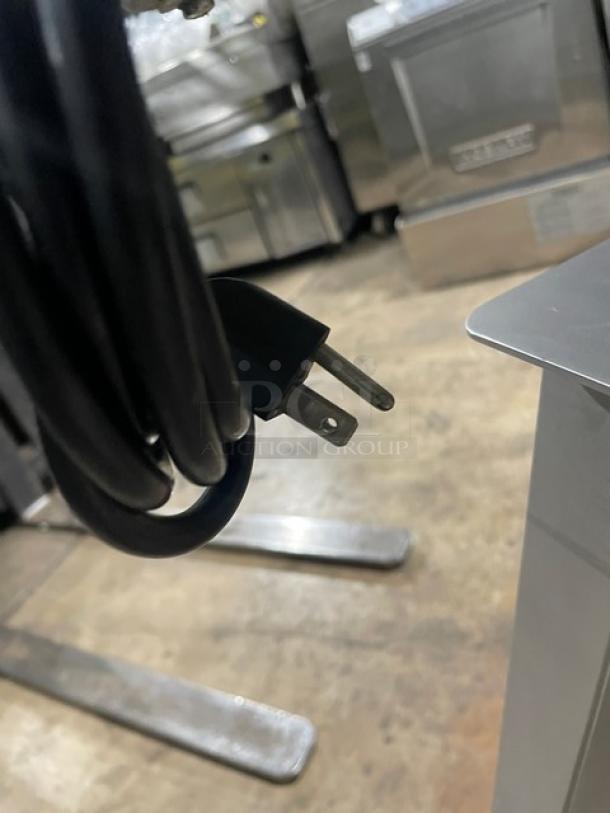 Jaccard VA2000GRT slicer power cord, three-prong plug, part of electric countertop slicer, shown near equipment stand.