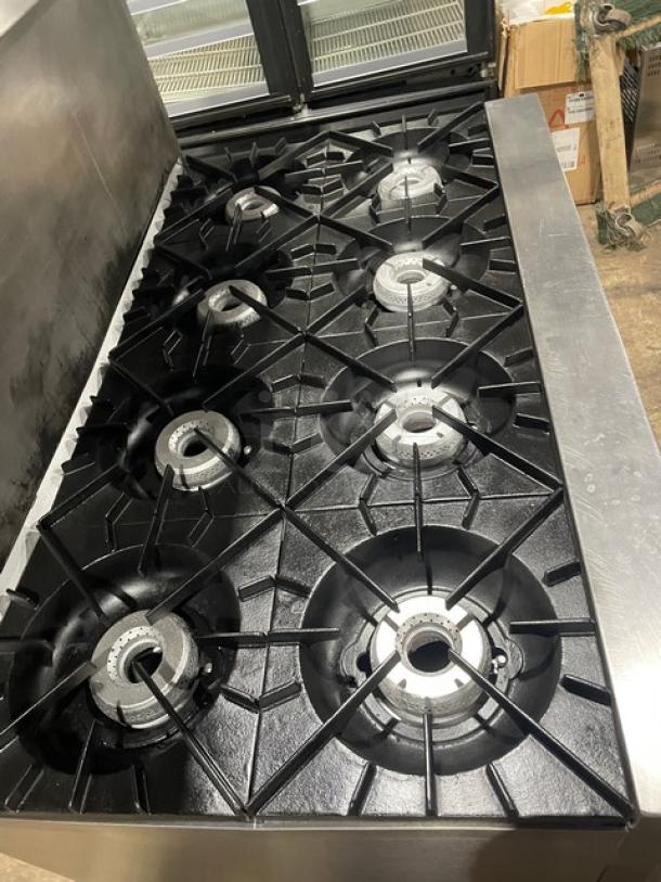 Vulcan commercial stainless steel 8 burner range/oven combo with backsplash, overhead salamander shelf, and caster wheels.