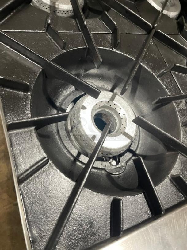 Vulcan stainless steel burner close-up, part of an 8-burner natural gas range/oven combo. Durable, commercial-grade.
