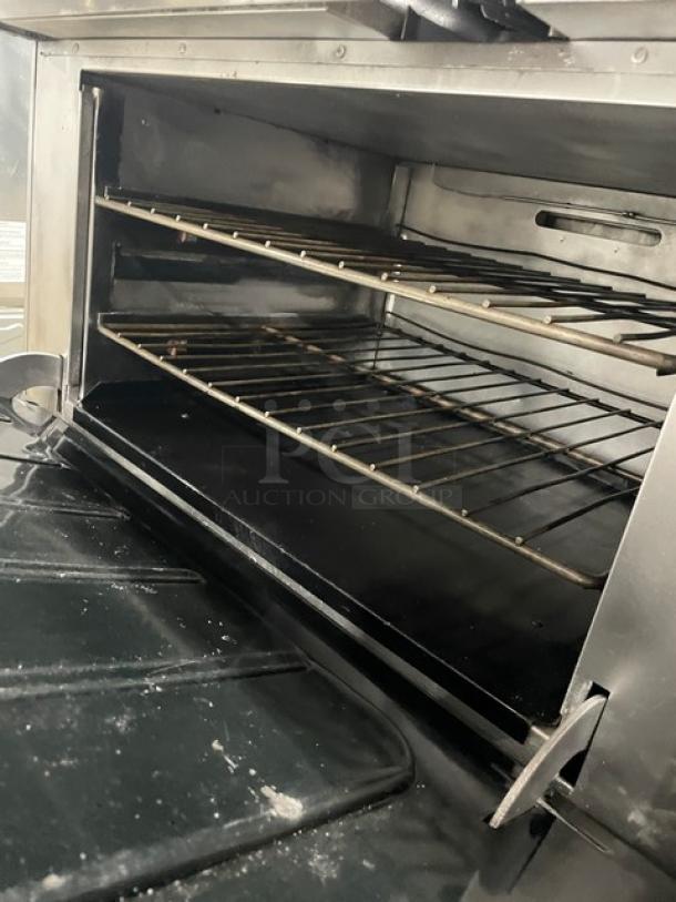 Vulcan stainless steel 8-burner range/oven combo with backsplash, overhead salamander shelf, cabinet storage, wired oven rack, on casters.