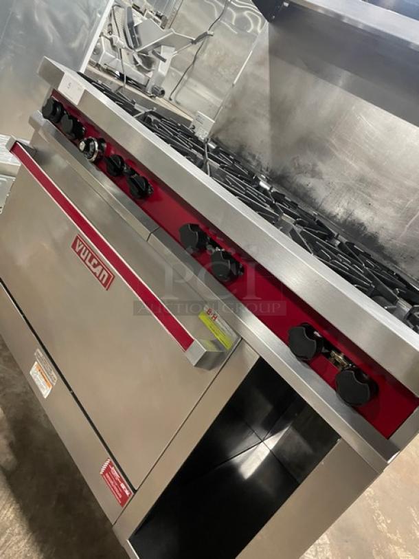 Vulcan commercial stainless steel 8 burner range/oven combo with back splash, overhead salamander shelf, and storage on casters.