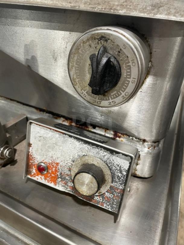 Market Forge Model 1600 stainless steel braising pan control panel, shows signs of wear, with temperature dials visible.