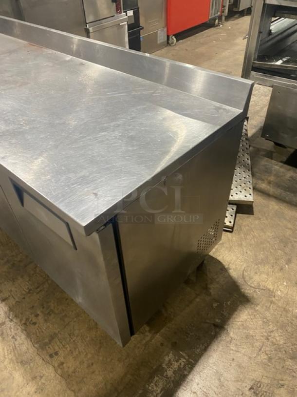 True TWT-72 stainless steel 3-door refrigerated worktop table, 72", with upturned backsplash, on casters, Energy Star certified.