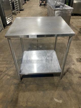 Commercial stainless steel worktop table with single undershelf on legs. Durable construction in good condition.