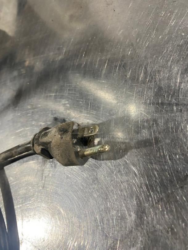 Old power plug of Vita-Mix VM0126 blender. Condition shows wear, visible on metal prongs and casing.