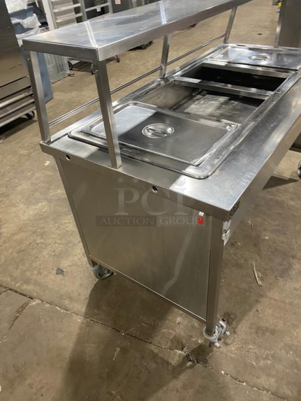 Atlas Metal stainless steel electric 4-well steam table with serve-over sneeze guard on casters, excellent condition.