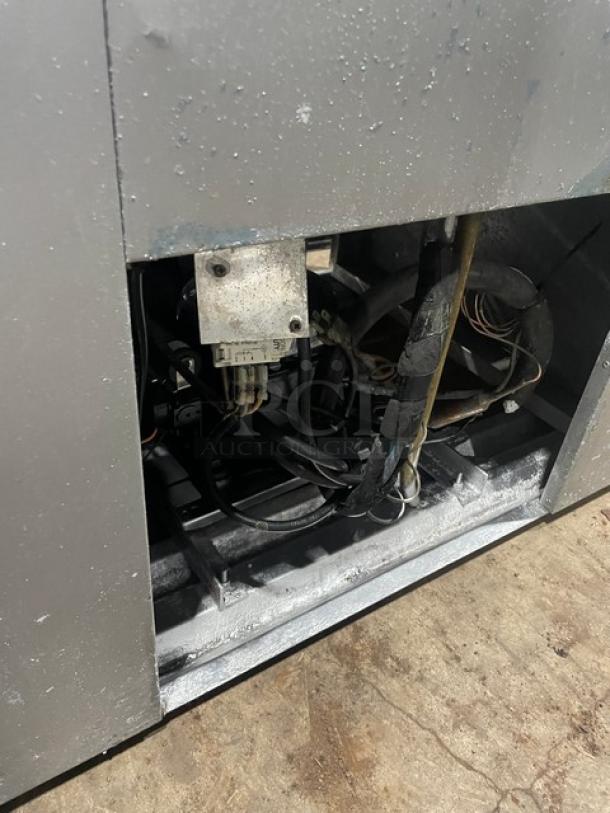 Leader commercial refrigerator with visible internal components, showing wiring and metal structure, suggesting maintenance needs.
