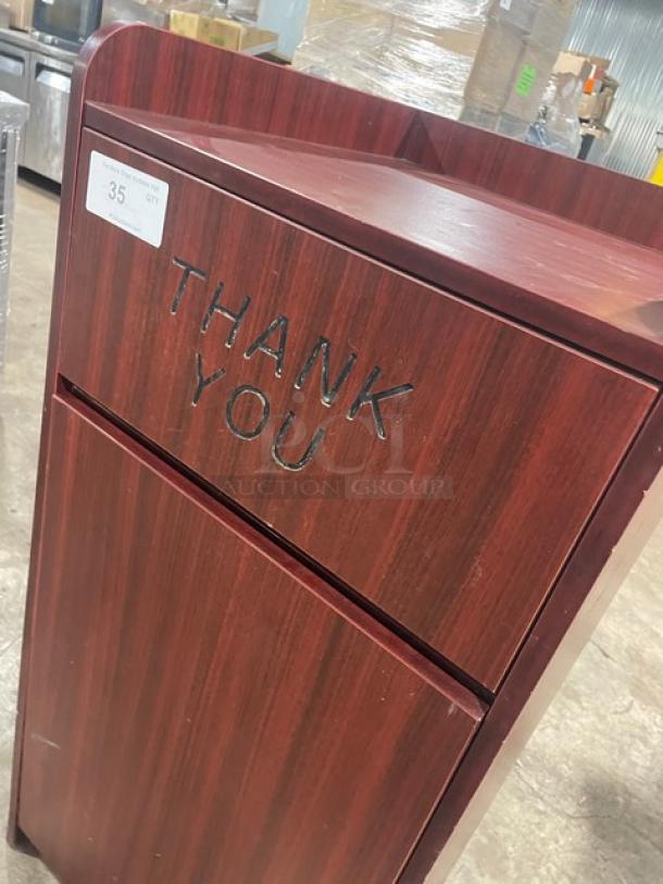 Commercial wooden enclosed trash cabinet with "Thank You" engraving. Rich wood finish, used condition, ideal for public spaces.