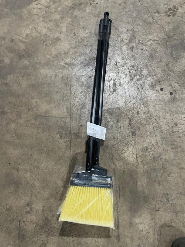 New commercial floor broom with black grip handle, yellow bristles; wrapped, labeled "37X."; pristine condition.