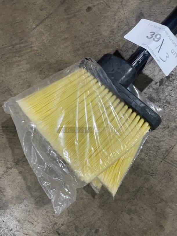 New commercial floor broom with yellow bristles, black grip handle, and plastic wrapping, auction tag reads "39 X 3".