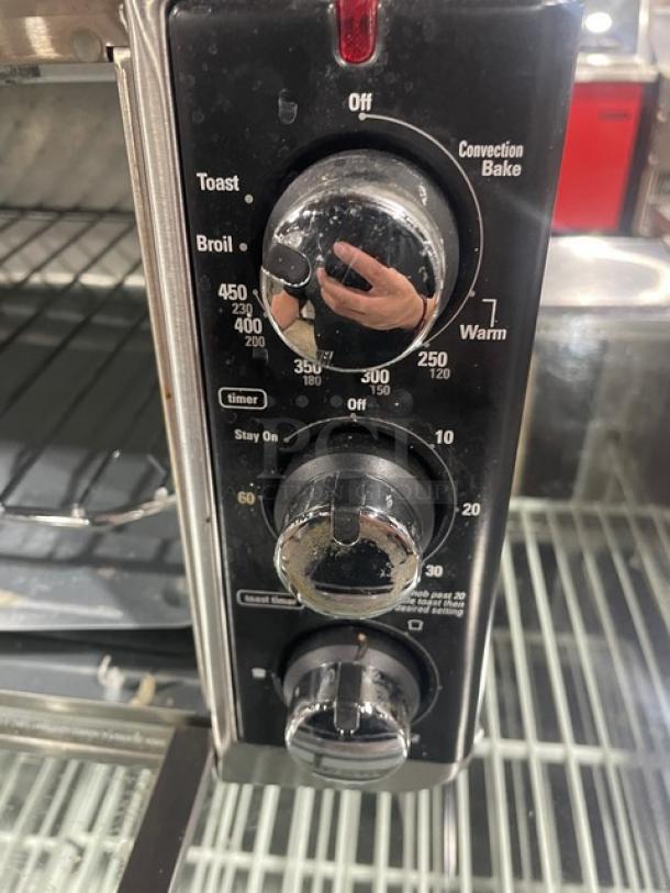BLACK+DECKER TO3250XSB convection toaster oven controls, showing temperature, timer, and function dials. Stainless steel.