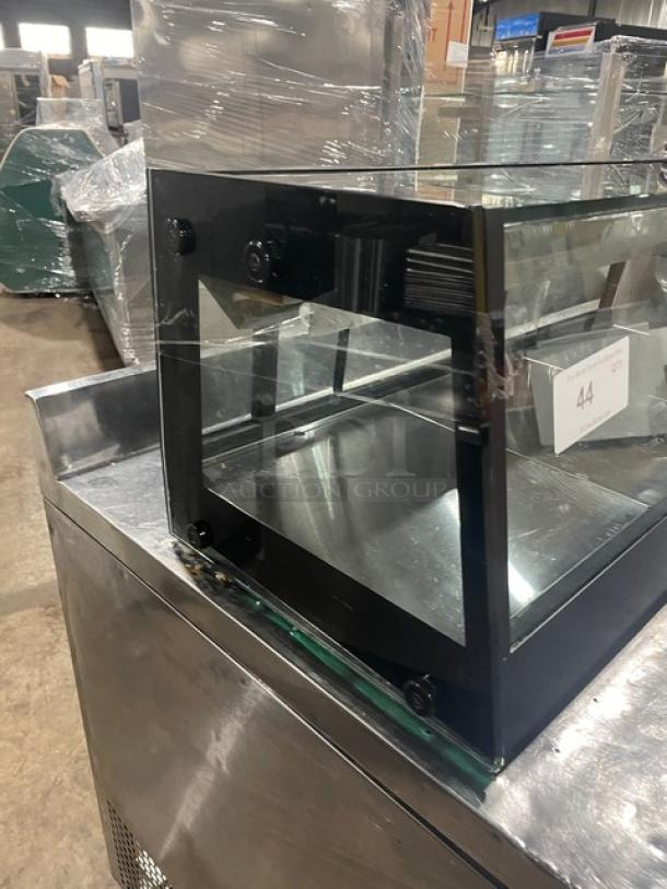 Turbo Air black refrigerated sushi display case with rear sliding doors, glass panels, and stainless steel base; like new condition.