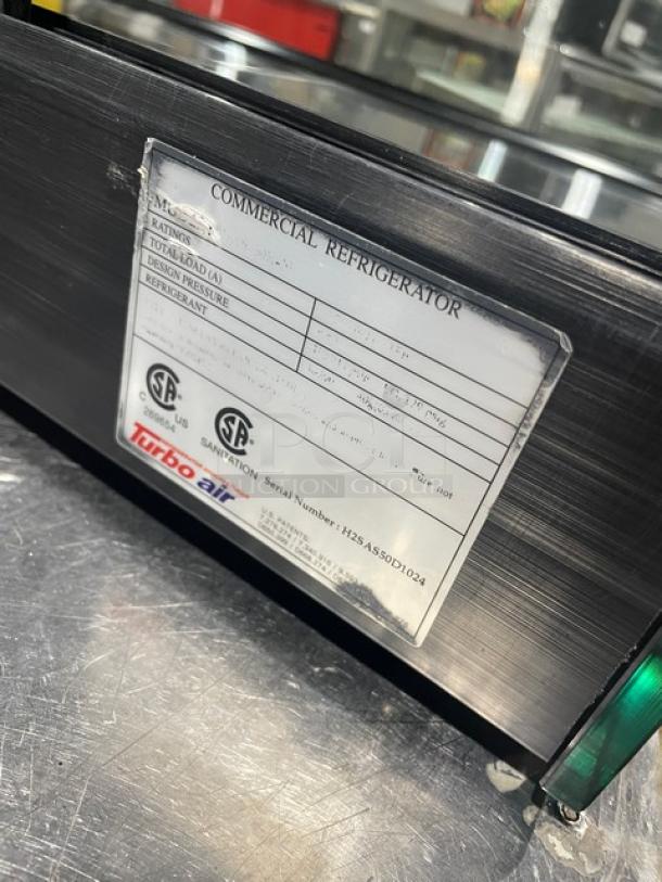 Turbo Air commercial black refrigerated countertop sushi merchandiser with rear sliding doors, label indicates model and specs.