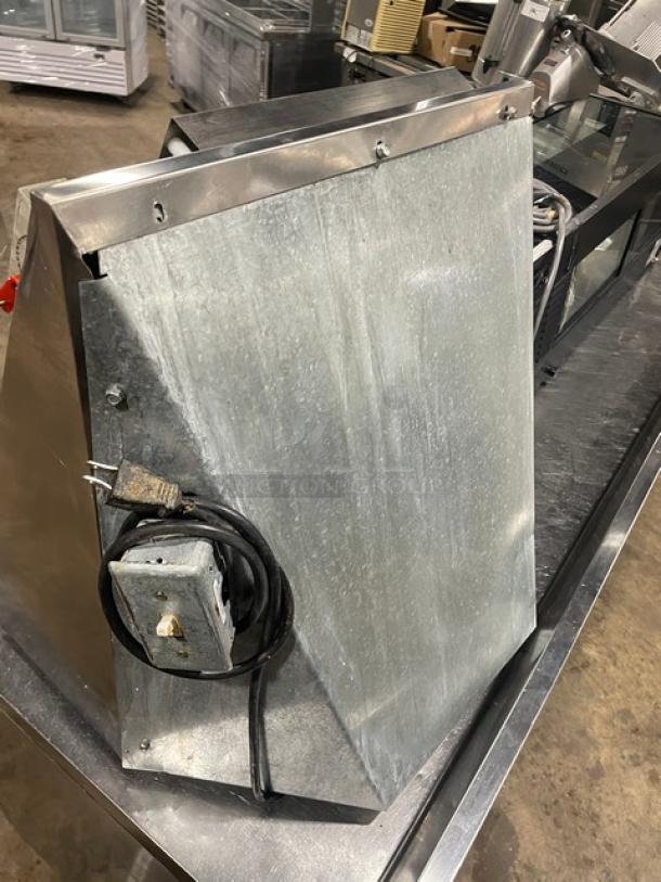 Stainless steel electric countertop dough sheeter, shows wear, power cord visible. Ideal for commercial use.