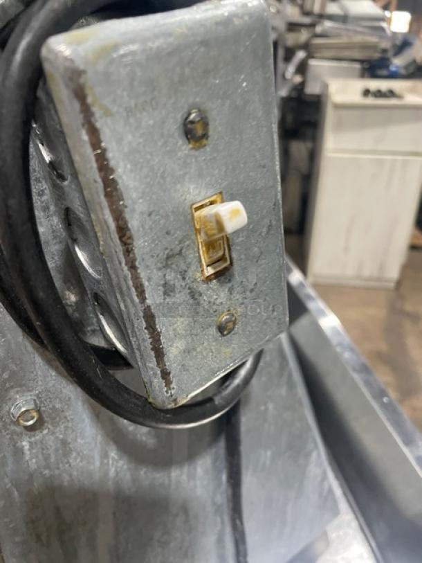 Commercial stainless steel electric countertop dough sheeter, showing a close-up of the power switch and electrical components.
