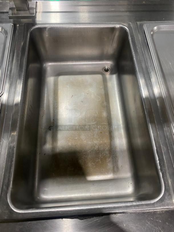 APW Wyott stainless steel 4-well hot food table with serve-over sneeze guard; used condition; electric-powered; on legs.