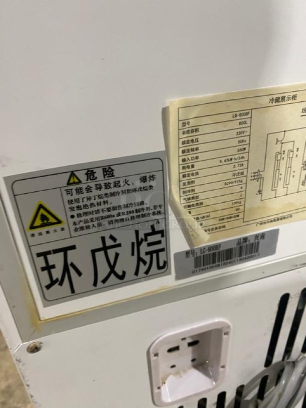 Commercial white double glass swing-door reach-in merchandiser refrigerator, model LG-800BF. Features poly-coated wire racks, 220V. Warning and specification labels visible.