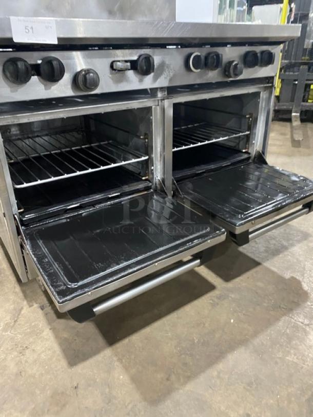 U.S. Range stainless steel 8-burner commercial natural gas range with double ovens, backsplash, overhead salamander shelf, and wired racks on legs.