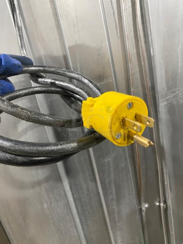 Yellow electrical plug of the Traulsen URS36DT refrigerator/freezer combo, shown against a metallic background.