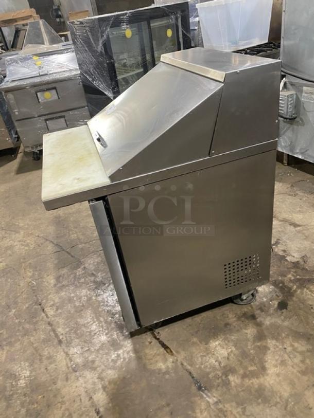 True stainless steel refrigerated prep table with Bain Marie style, cutting board, and wire rack. Model TSSU-27-12M-C, on casters.