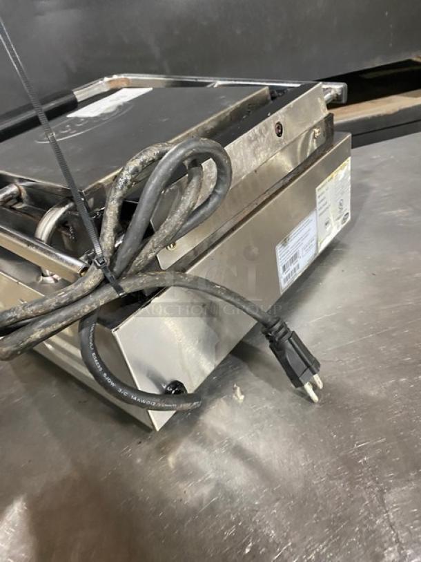 Globe stainless steel electric panini grill with grooved grates, thermostatic control, 120V, on legs, visible power cord.