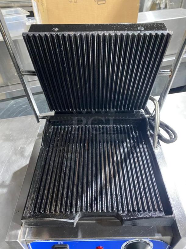 Globe commercial stainless steel countertop panini grill, electric, grooved top & bottom grates, thermostatic control, 120V.