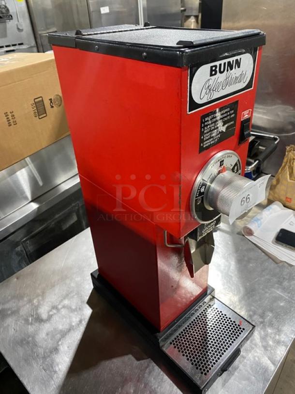 Bunn G3 red commercial coffee grinder, electric-powered, model SN: 8406, 120V 1 Phase. Features dial controls, visible Bunn label.