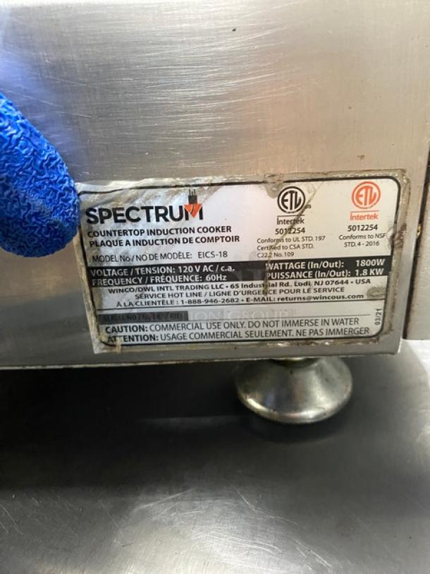 Winco Spectrum Series EICS-18 induction range, stainless steel, model and voltage label visible, on legs, commercial use.