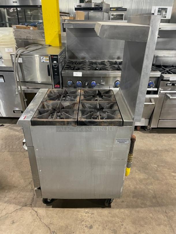 Cookline commercial stainless steel 4-burner range/oven combo with backsplash, overhead salamander shelf, and gas connection hose on casters.