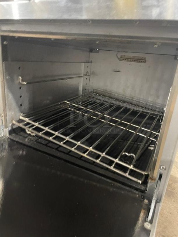 Cookline stainless steel 4-burner gas range/oven combo with backsplash, overhead salamander shelf, and wired oven racks.
